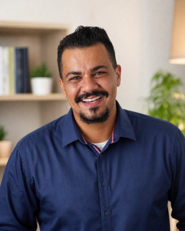 Magnus Arantes, psicólogo, sorrindo em seu consultório em Divinópolis